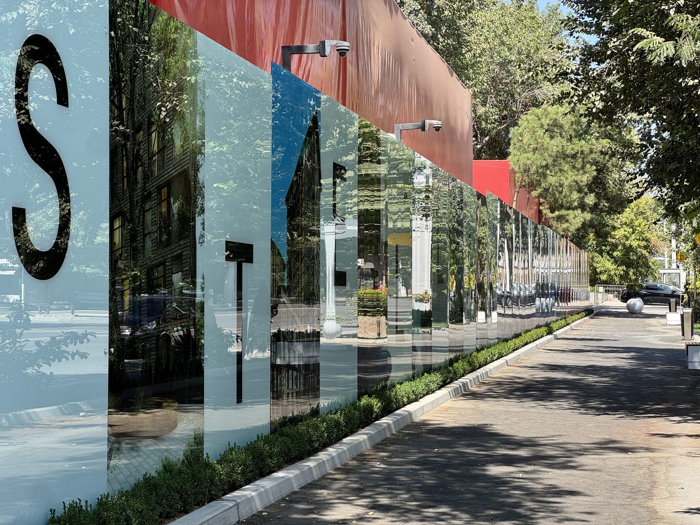 Large letterforms on mirror glass hoarding panels